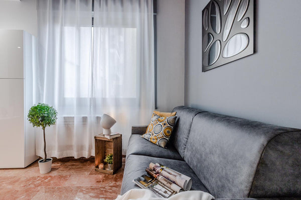 Designer glass mirror panel featuring an artistic cut-out pattern, reflecting light beautifully in a contemporary interior.