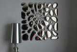 Modern glass mirror wall art in an abstract arrangement, enhancing interior aesthetics with a reflective surface.
