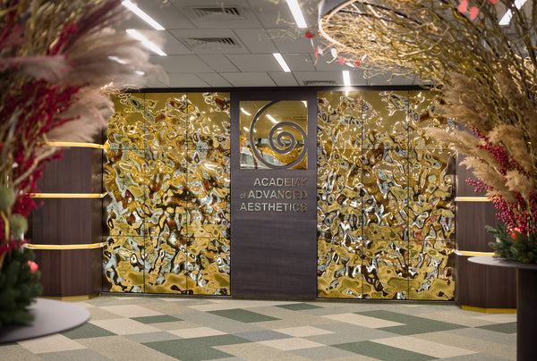 Aqua High Wave gold glass panels at the Academy of Advanced Aesthetics, featuring a luxurious, reflective, and wavy texture that enhances the interior design