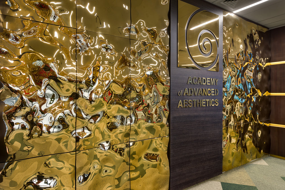 Luxury wall panels – Close-up of the luxury glass wall panel "Aqua High Wave" in a gold finish, with light reflecting off the panels