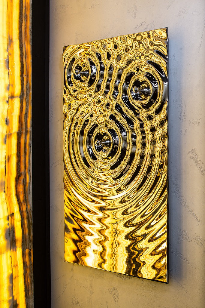 A stunning artistic towel rack with a reflective gold and black finish, adding elegance to any space.
