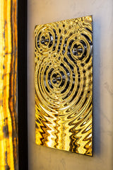 A stunning artistic towel rack with a reflective gold and black finish, adding elegance to any space.
