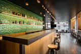 Modern bar interior featuring illuminated Green Planet glass panels as a backdrop.