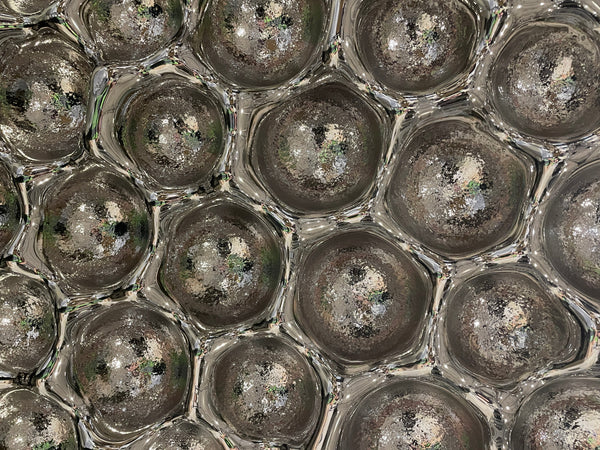 Close-up of Bubble Reverse mirror wall sculpture with metallic bubble textures, creating a futuristic aesthetic