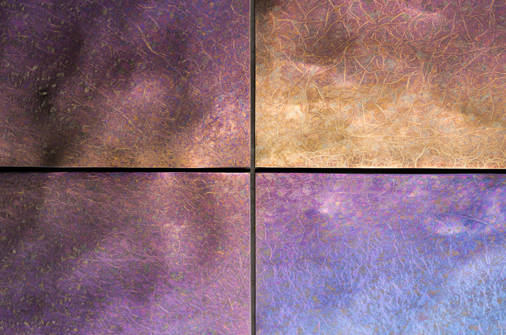 Luxurious chameleon glass wall panel with intricate textures and iridescent hues, reflecting a blend of blue, purple, and gold tones. A modern and artistic decorative glass panel ideal for upscale interiors