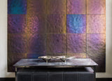 Luxury interior featuring a statement wall of chameleon glass panels with an iridescent metallic finish in deep purple, bronze, and blue hues. A modern design element complemented by an elegant console table and decorative PlusObject's Flow platter.