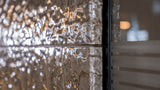 Detailed view of champagne glass wall panels with a rippled texture, reflecting ambient lighting