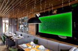 Flora green glass wall panel with backlit green illumination, seamlessly integrated into a stylish restaurant interior with wooden accents.
