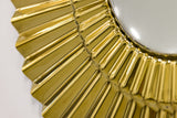 Close-up of golden sunburst wall decor showing intricate glass details.