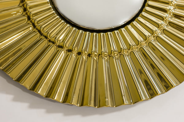 Angled shot of the golden sunburst wall decor highlighting its three-dimensional form