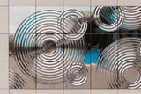 Interference exterior glass wall panel with concentric circular relief and reflective chrome finish
