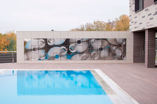 Exterior installation of Interference glass panels near a swimming pool, reflecting the surroundings.