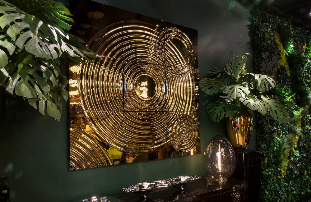 Illuminated golden Interference glass panel mounted in a dark, tropical-inspired space.