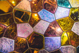 Iridescent glass mosaic wall art with a blend of gold, blue, and bronze hues, creating a mesmerizing decorative accent.
