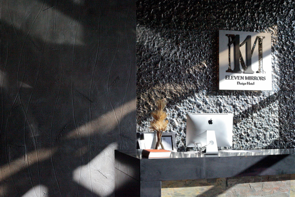 Close-up of the luxury Vento Silver wall panel featuring a textured mirrored glass surface with dynamic reflections.