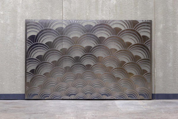 The Mermaid glass wall panel displayed against a concrete wall, showcasing its full design with an elegant wave pattern.