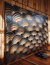The Mermaid panel installed in a wooden interior, with warm lighting accentuating its sculptural glass design.