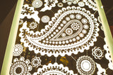 The Paisley Pattern mirrored glass wall panel illuminated, showcasing its intricate paisley and floral designs with reflective and frosted details.