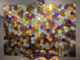 Luxury polygonal glass mosaic wall decor with a shimmering metallic finish, reflecting gold, blue, and purple tones.