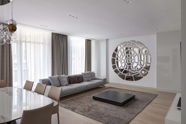 Spiral mirror wall art composition in a modern living room
