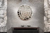 Elegant spiral mirror wall art mounted on a textured luxury interior wall.