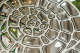 Statement mirror wall decor piece, the Spiral Mural, showcasing a unique geometric reflection.