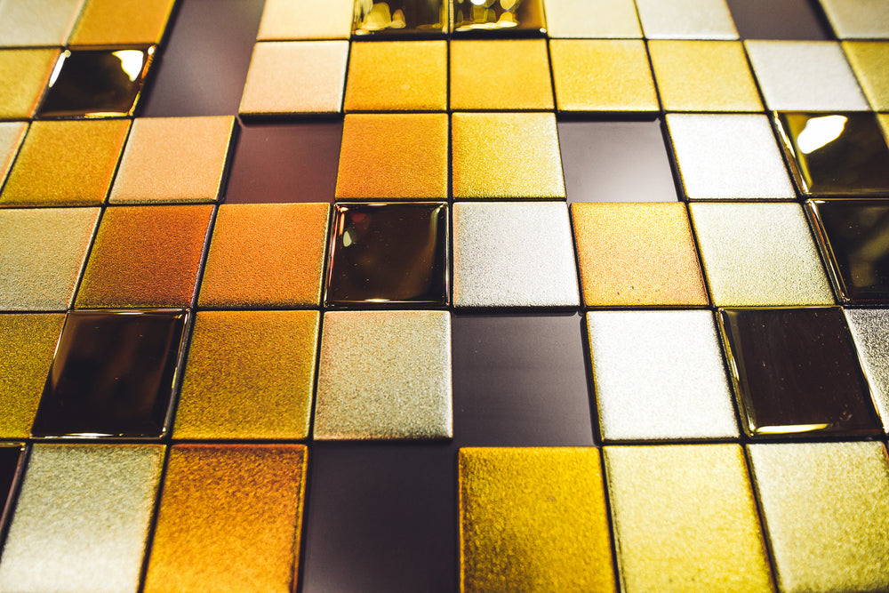 Gold and silver Tetris-style glass wall panel with a mix of glossy and matte finishes, creating a luxurious and geometric aesthetic.